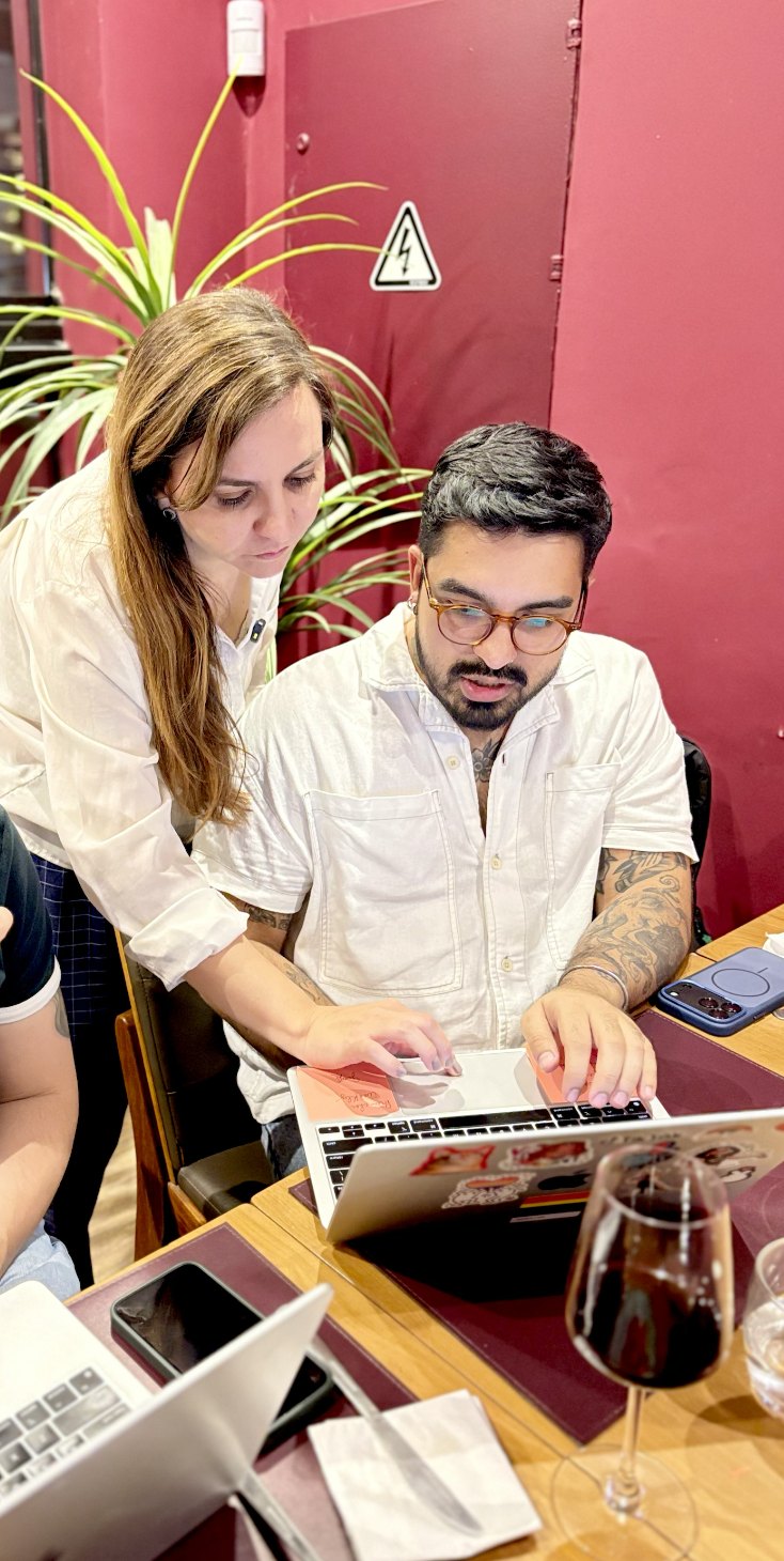 Facilitadora da Claud.IA ajudando um participante no notebook durante o workshop in-company